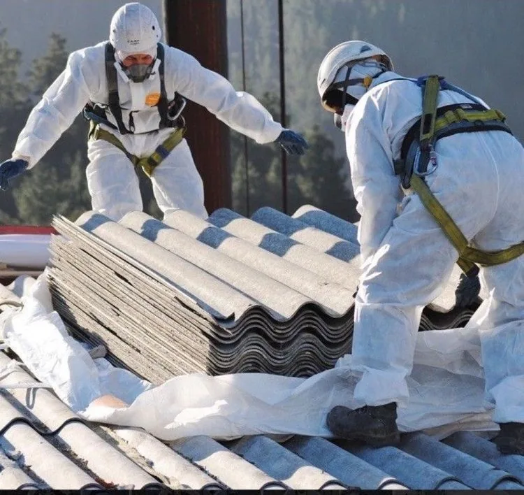 Stack of profiled grey fibre-cement roof sheets awaiting identification