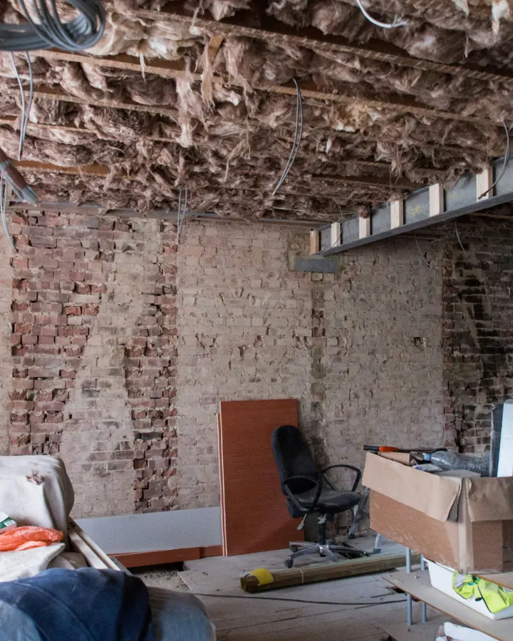 Ceiling stripped back to the joists with insulation and wiring exposed